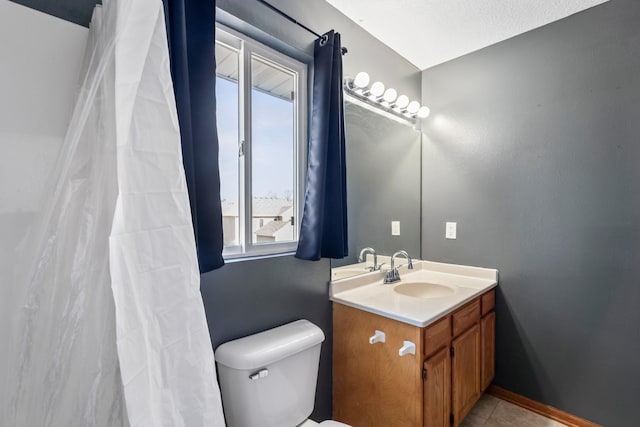 bathroom with vanity, tile patterned floors, toilet, and baseboards