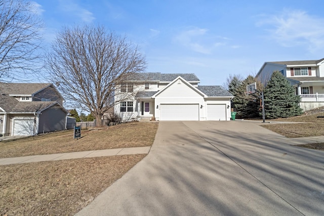 traditional-style house featuring a garage, concrete driveway, and fence