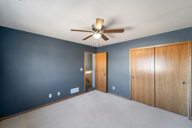 unfurnished bedroom with visible vents, baseboards, carpet floors, a closet, and a textured ceiling