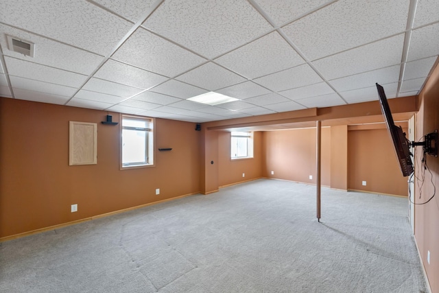 below grade area featuring carpet, visible vents, a drop ceiling, and baseboards