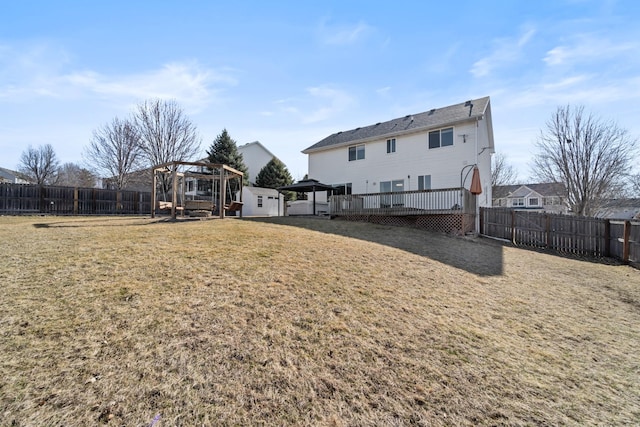 back of house with a yard, a deck, and a fenced backyard