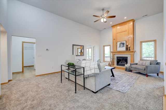 carpeted living room with a high ceiling, a wealth of natural light, and ceiling fan