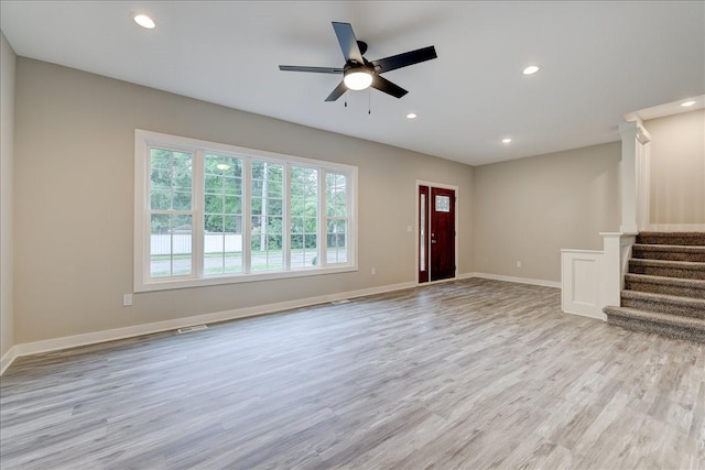 unfurnished living room featuring ceiling fan and light wood-type flooring