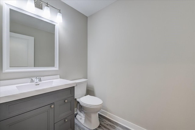 bathroom with hardwood / wood-style floors, vanity, and toilet