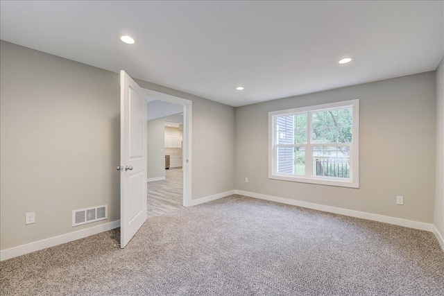 unfurnished room featuring light colored carpet