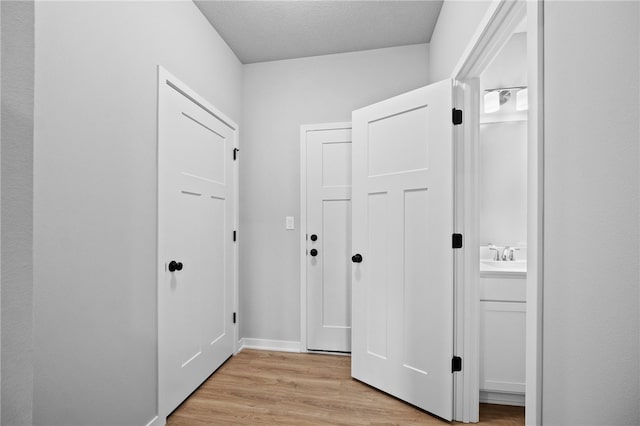 hallway with light hardwood / wood-style floors