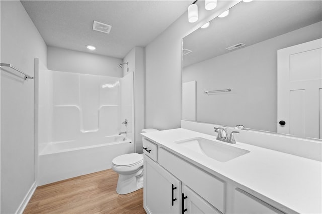 full bathroom with a textured ceiling, toilet, shower / washtub combination, vanity, and hardwood / wood-style flooring