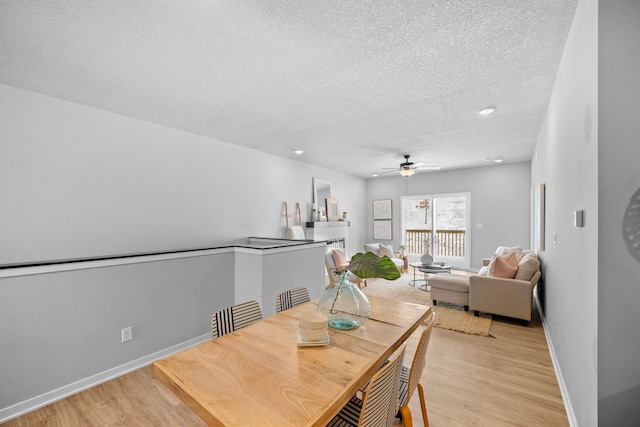 dining room with ceiling fan, light hardwood / wood-style floors, and a textured ceiling