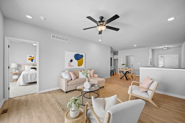 living room with light hardwood / wood-style flooring and ceiling fan