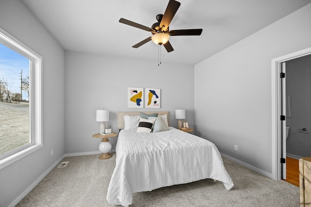 carpeted bedroom with multiple windows and ceiling fan