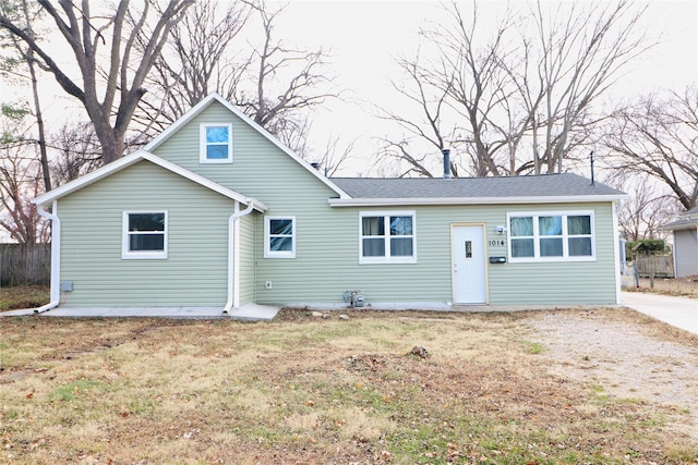 rear view of property featuring a lawn