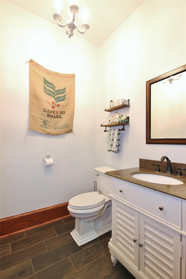 bathroom featuring an inviting chandelier, vanity, and toilet