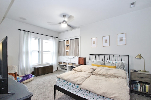 bedroom with carpet flooring, a ceiling fan, visible vents, and radiator heating unit