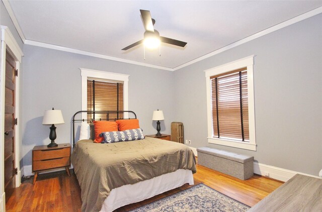 bedroom with hardwood / wood-style flooring, ceiling fan, and ornamental molding