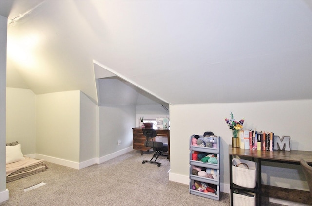 carpeted home office with vaulted ceiling and baseboards