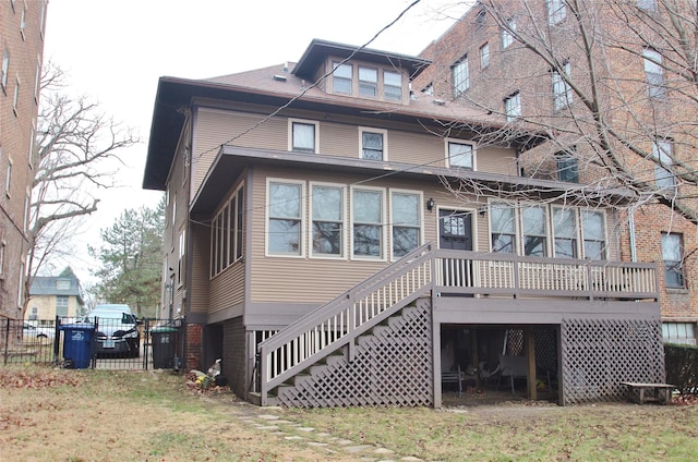 rear view of property with a yard, stairs, and fence