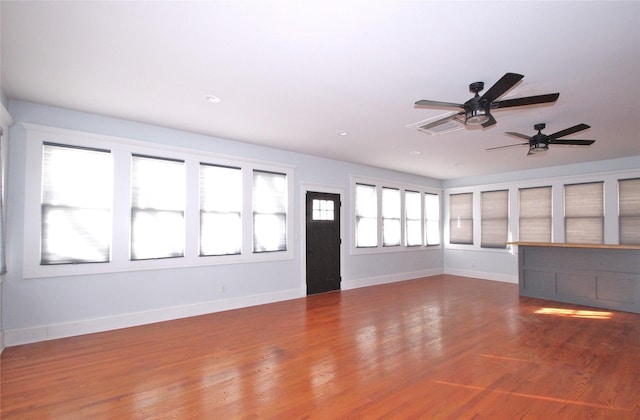 unfurnished living room with wood finished floors and baseboards