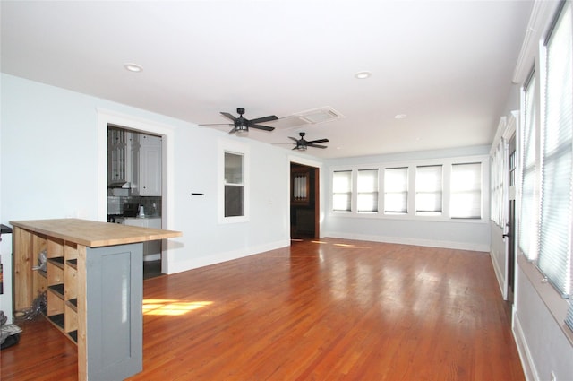 unfurnished living room featuring recessed lighting, ceiling fan, baseboards, and wood finished floors