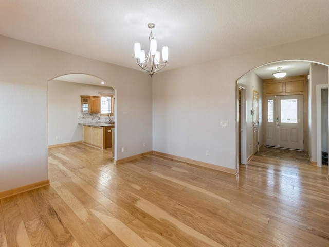 interior space with a notable chandelier and light wood-type flooring