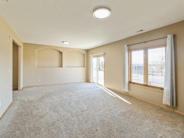 carpeted spare room featuring a textured ceiling