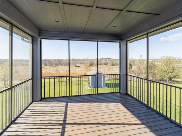 unfurnished sunroom featuring a healthy amount of sunlight and a rural view