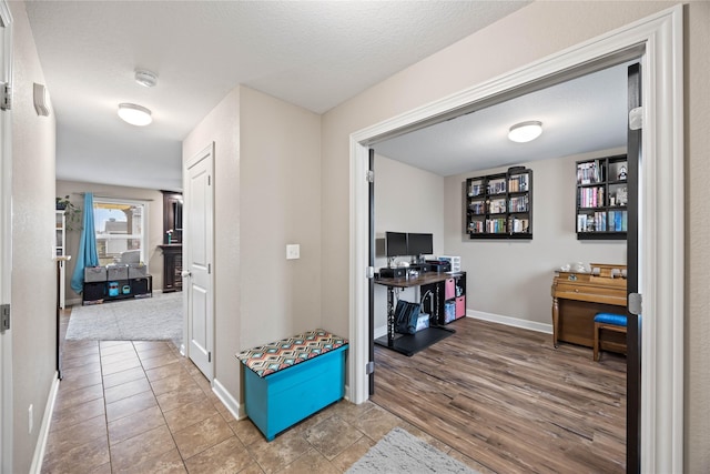 hall with wood-type flooring and a textured ceiling