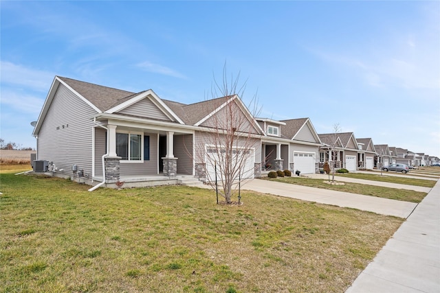 view of front of property with a garage, covered porch, central air condition unit, and a front yard