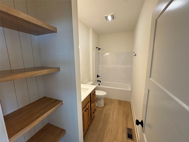 full bath featuring toilet, visible vents, wood finished floors, and bathing tub / shower combination