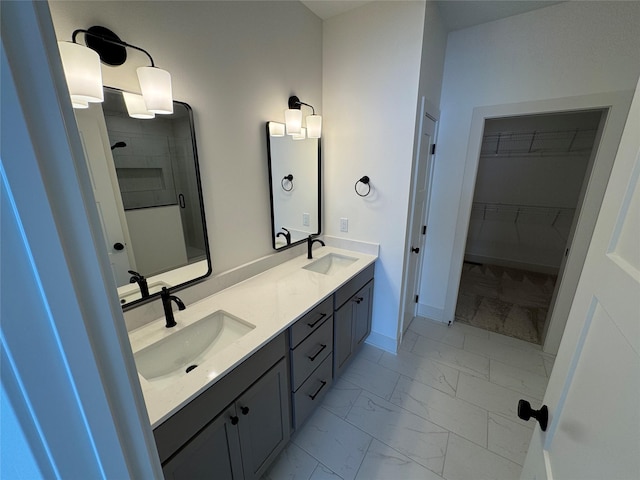 full bathroom featuring marble finish floor, double vanity, a shower, and a sink