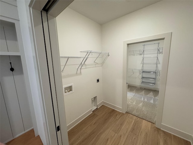 washroom featuring washer hookup, light wood-type flooring, electric dryer hookup, and baseboards