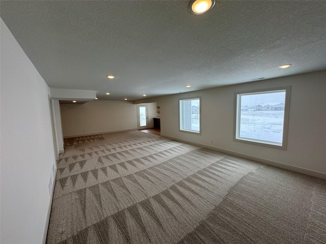 interior space featuring recessed lighting, visible vents, light carpet, a textured ceiling, and baseboards