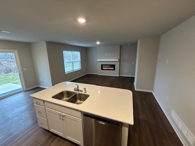 kitchen with dishwasher, sink, dark hardwood / wood-style floors, an island with sink, and white cabinetry