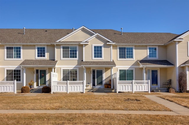 townhome / multi-family property featuring a shingled roof and covered porch