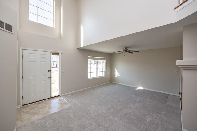 entryway featuring carpet, a towering ceiling, and visible vents