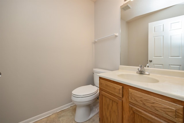 half bathroom featuring baseboards, visible vents, toilet, tile patterned flooring, and vanity