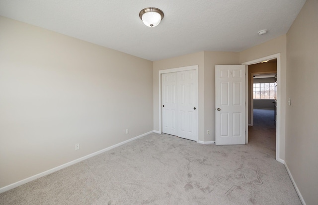 unfurnished bedroom featuring carpet floors, a closet, and baseboards