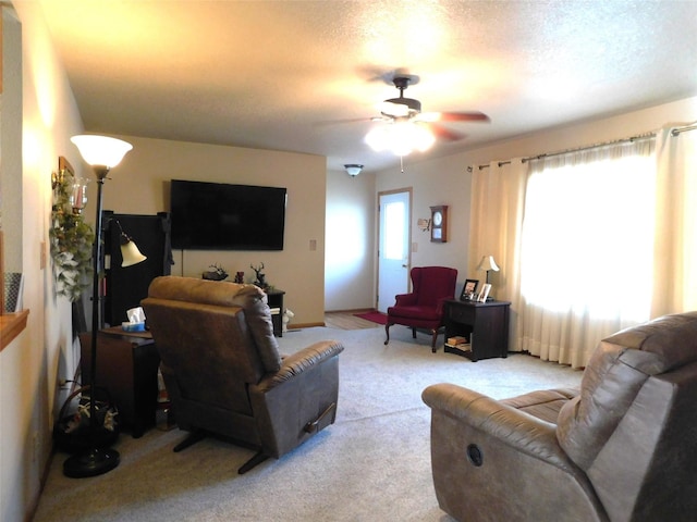 carpeted living room featuring a textured ceiling and ceiling fan