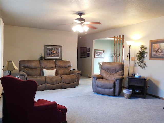 carpeted living room featuring ceiling fan and a textured ceiling