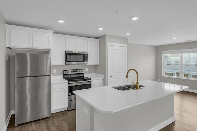 kitchen featuring a center island with sink, white cabinets, sink, and appliances with stainless steel finishes