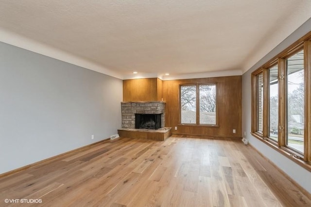 unfurnished living room featuring a fireplace and light hardwood / wood-style floors