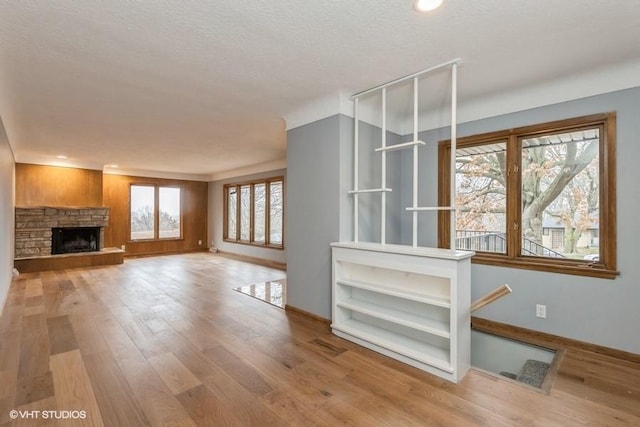 unfurnished living room featuring hardwood / wood-style floors, a fireplace, and a healthy amount of sunlight