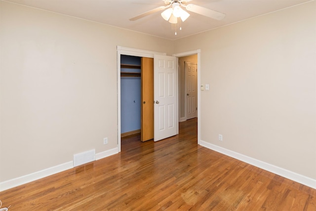 unfurnished bedroom featuring wood-type flooring, a closet, and ceiling fan