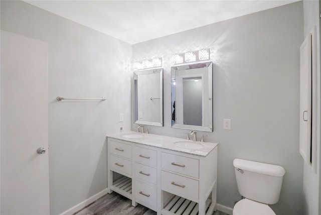 bathroom with hardwood / wood-style flooring, vanity, and toilet