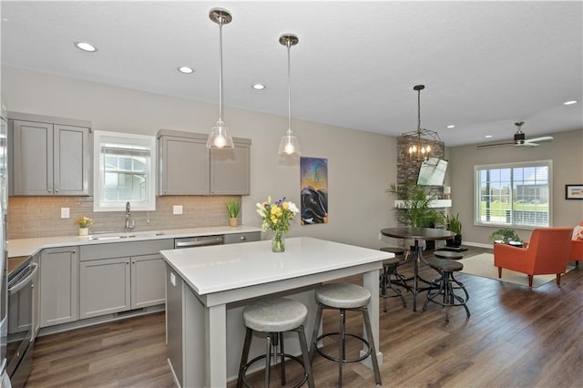 kitchen with ceiling fan, a kitchen island, stainless steel electric range, and sink