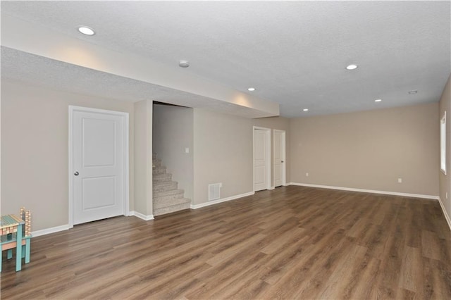 spare room featuring dark hardwood / wood-style flooring and a textured ceiling