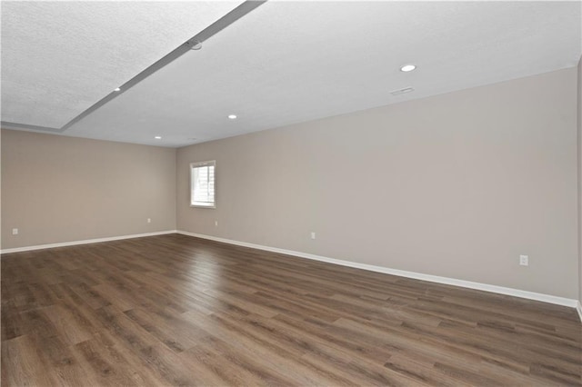 empty room featuring dark wood-type flooring and a textured ceiling