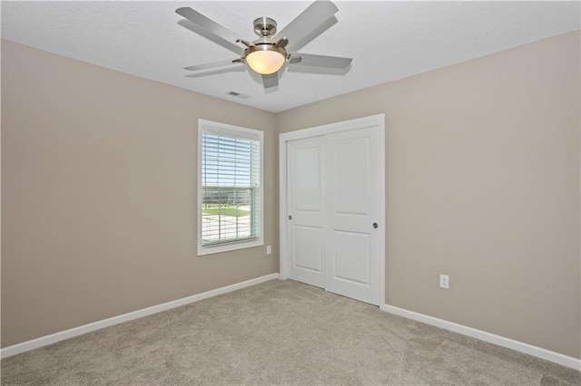 carpeted spare room with ceiling fan