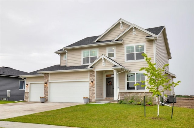 craftsman-style house featuring cooling unit, a garage, and a front lawn