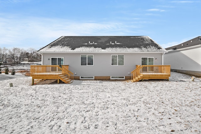 snow covered house with a deck