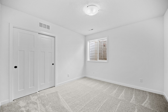 unfurnished bedroom featuring light carpet and a closet